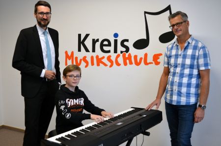 Musikschüler Fernando Piras(11) griff als erster in die Tasten  – v.l. Patrick Pelkmann (Volksbank) und Eddi Kleinschnittger (Leiter Kreismusikschule) 